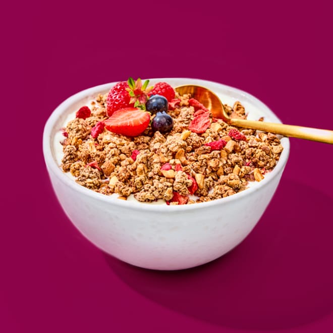 Granola Einsteiger Paket in einer weißen Schüssel mit Beeren und einem goldenen Löffel